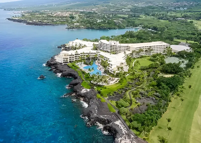 A resort with an ocean view and green vegetation.